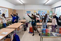 Uns infants aixequen la mà a classe